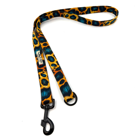 Leopard print dog leash with black clip on a white background