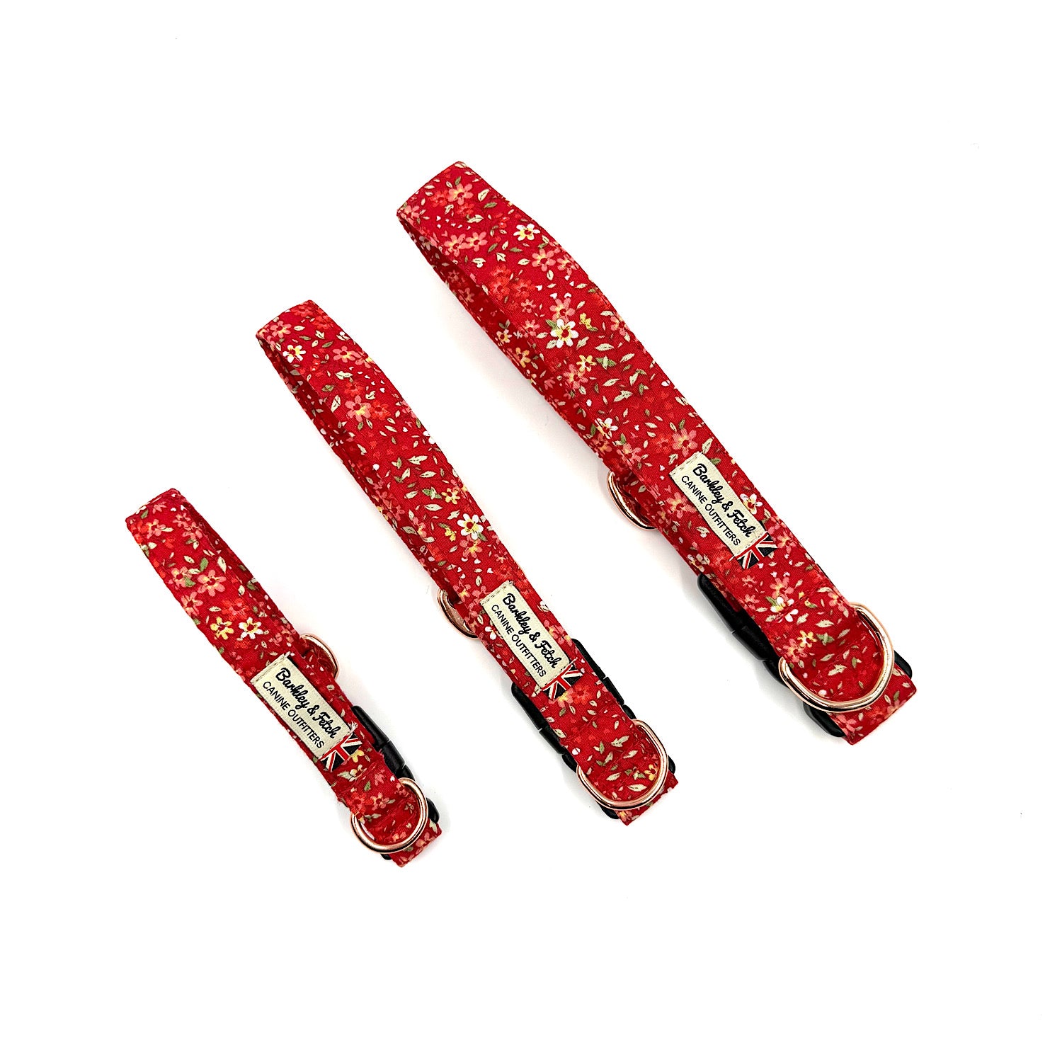 Set of three red floral-patterned dog collars on a white background